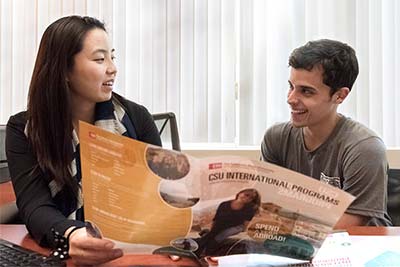 advisor reviewing CSU International Programs brochure with student